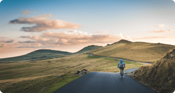 A man cycling through the country side.