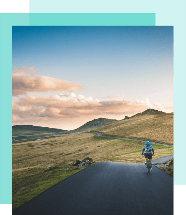 A man cycling through the country side.