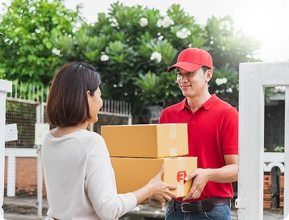 A delivery personell giving a customer her parcel.