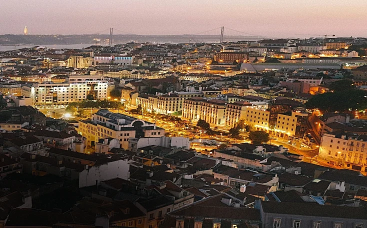 An urban city lit up with lights at dusk.
