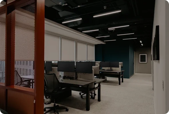 Company office with desks containing several screens.