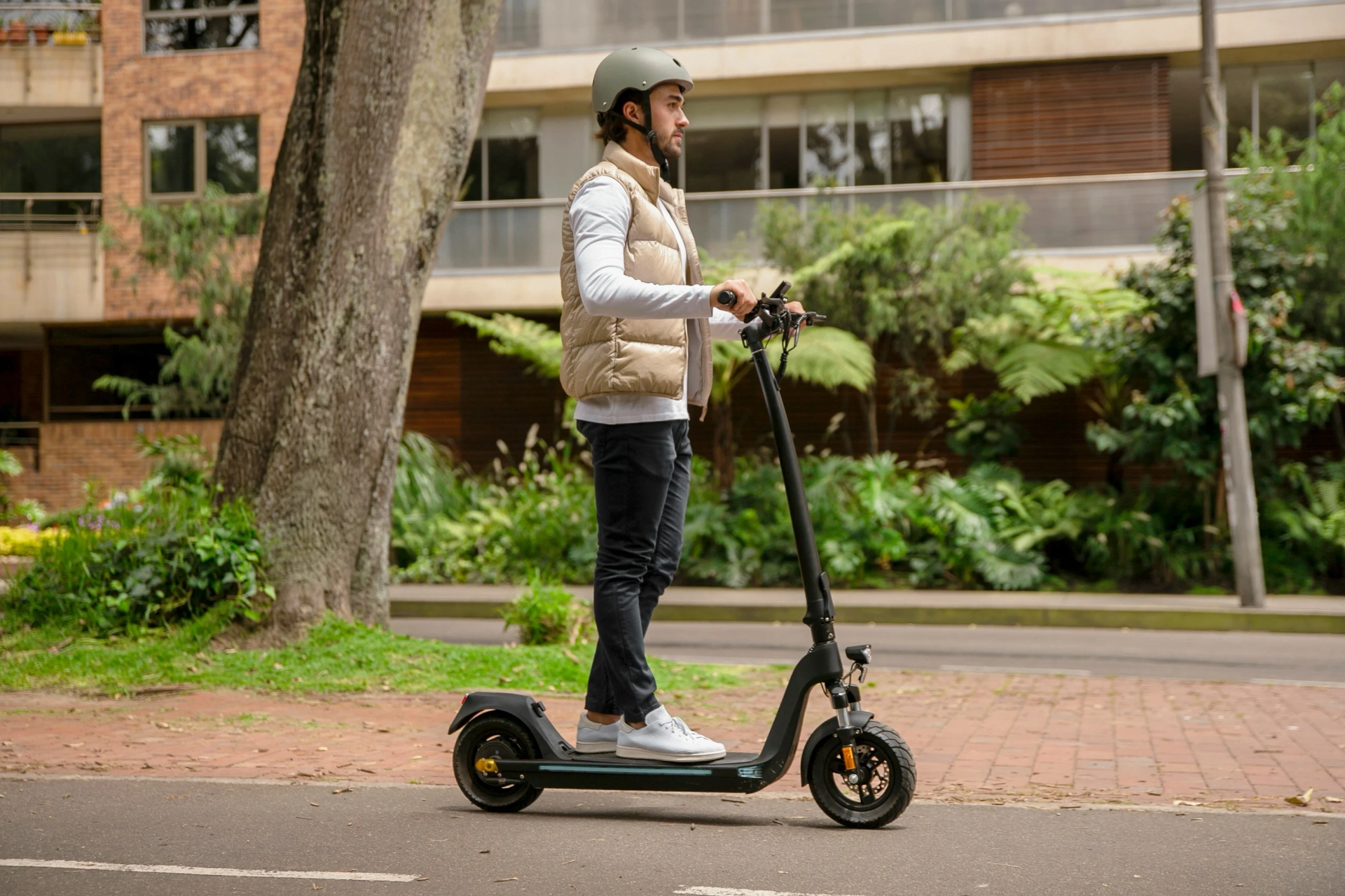 A man riding a scooter with an helment on.